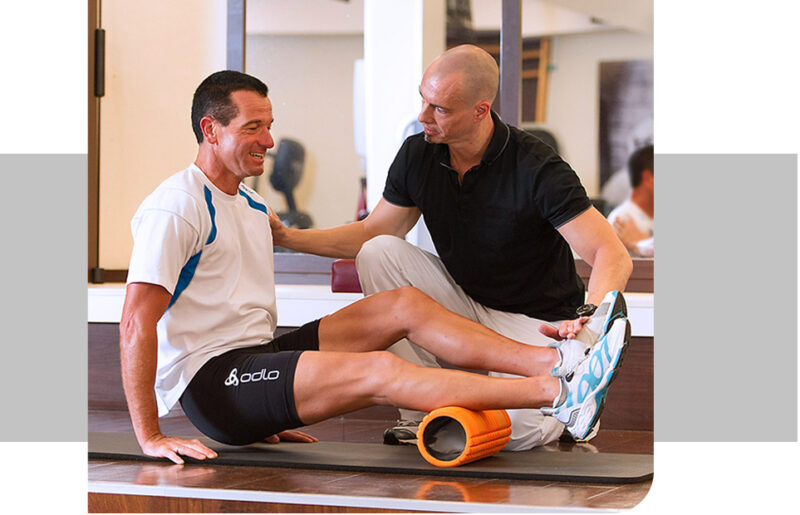 Klient mit Personal Trainer Guido Halver beim Faszienrollen Training